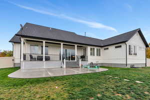 Back of property featuring a lawn and a patio