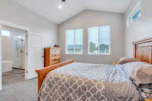 Bedroom featuring ensuite bath and lofted ceiling