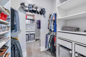 Walk in closet with light colored carpet