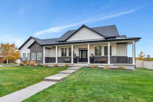 View of front of property with covered porch and a front lawn