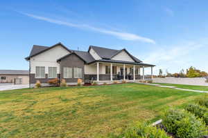 View of front facade featuring a front yard and a porch