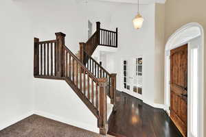 Entryway with dark hardwood / wood-style floors, a towering ceiling, and french doors