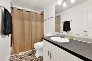 Full bathroom with vanity, toilet, and shower / bath combo with shower curtain