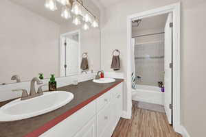 Full bathroom featuring hardwood / wood-style flooring, vanity, toilet, and shower / bath combo with shower curtain