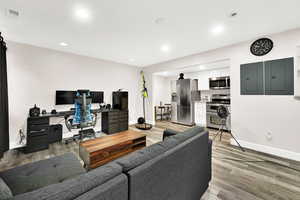 Living room featuring electric panel and light hardwood / wood-style flooring