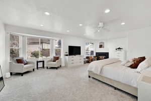 Carpeted bedroom featuring multiple windows and ceiling fan