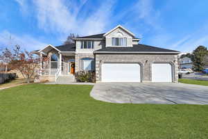 View of front of home featuring a front yard and a garage