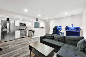 Living room with electric panel and light hardwood / wood-style floors