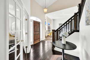 Foyer entrance featuring dark hardwood / wood-style flooring and high vaulted ceiling