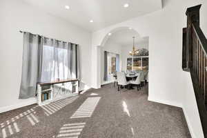 Unfurnished dining area with a chandelier and carpet floors