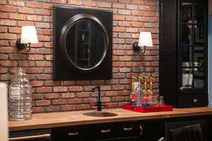 Interior space with sink, brick wall, and wooden counters