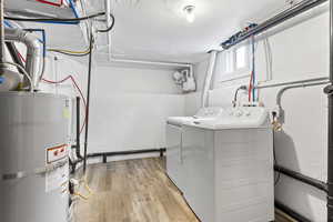 Clothes washing area featuring washing machine and dryer and water heater