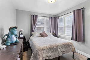 Carpeted bedroom featuring multiple windows and a textured ceiling