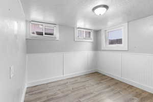 Spare room featuring a textured ceiling and light hardwood / wood-style flooring