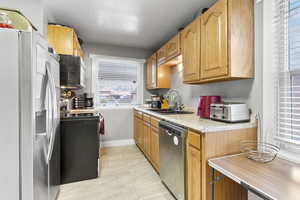 Kitchen featuring a textured ceiling, stainless steel appliances, and sink