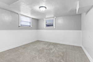 Carpeted empty room featuring a textured ceiling