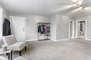 Living area with a textured ceiling and carpet floors