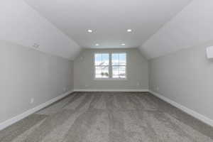 Bonus room featuring carpet flooring and lofted ceiling