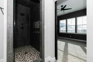 Bathroom with ceiling fan and a shower with door