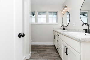 Bathroom featuring vanity, hardwood / wood-style flooring, and toilet