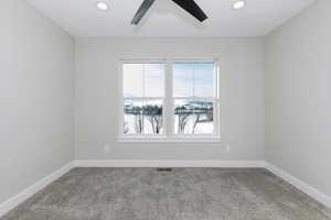 Carpeted empty room with ceiling fan