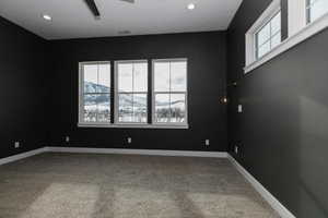 Empty room featuring a mountain view and carpet floors