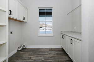 Laundry room with cabinets, dark hardwood / wood-style floors, and electric dryer hookup