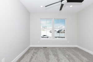 Empty room with light carpet and ceiling fan