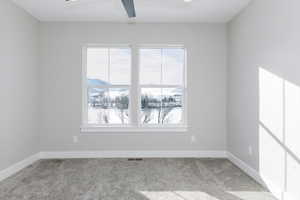 Carpeted empty room with ceiling fan