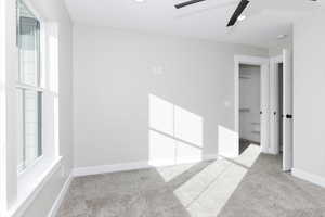 Carpeted empty room with ceiling fan