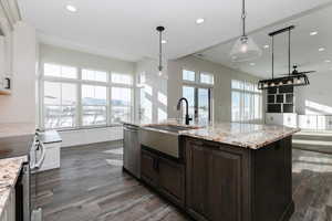 Kitchen featuring a center island with sink, decorative light fixtures, sink, and stainless steel appliances