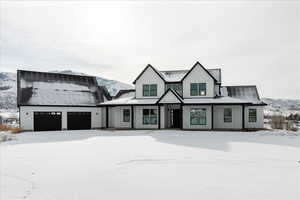 Modern farmhouse style home featuring a mountain view and a garage