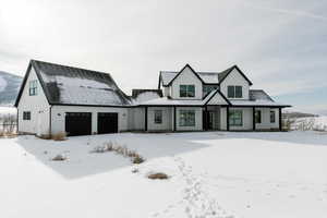 Modern farmhouse featuring a porch and a garage