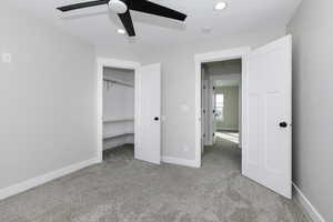 Unfurnished bedroom featuring ceiling fan, a closet, and light carpet