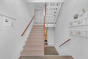 Stairs with a towering ceiling and brick wall