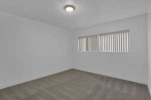 Carpeted empty room featuring a healthy amount of sunlight and a textured ceiling