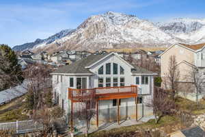 Snow covered rear of property featuring a deck with mountain view