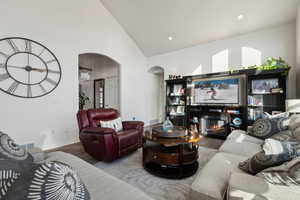 Living room featuring high vaulted ceiling and hardwood / wood-style LVP flooring