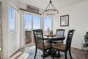 Dining room featuring wood-type LVP flooring and a notable chandelier