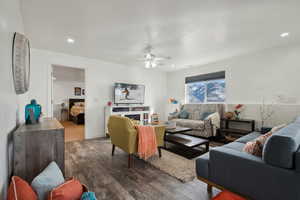 Living room featuring ceiling fan and dark tile wood-type flooring