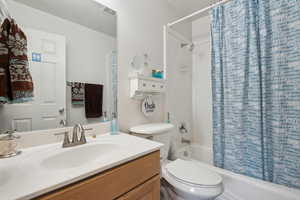 Full bathroom with vanity, toilet, and shower / bathtub combination with curtain