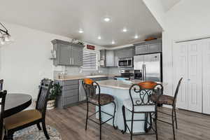 Kitchen featuring gray cabinets, stainless steel appliances, and  wood-type LVP flooring