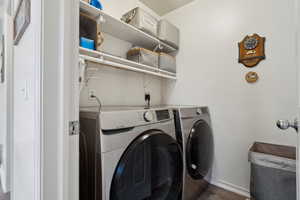 Laundry area with dark hardwood / wood-style floors and independent washer and dryer