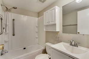 Full bathroom featuring vanity, toilet, and washtub / shower combination