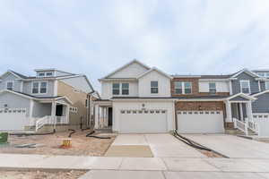 View of front facade featuring a garage, board and batten siding, and concrete driveway