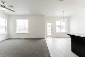 Interior space with recessed lighting, ceiling fan with notable chandelier, a textured ceiling, and baseboards