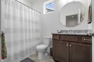 Bathroom with tile patterned floors, vanity, and toilet