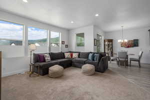 Living room with a mountain view, hardwood / wood-style floors, and a notable chandelier