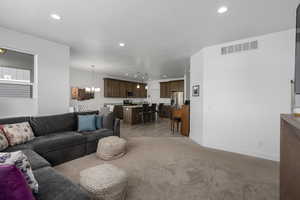 Living room with light colored carpet and a notable chandelier