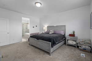 Bedroom featuring light carpet and connected bathroom